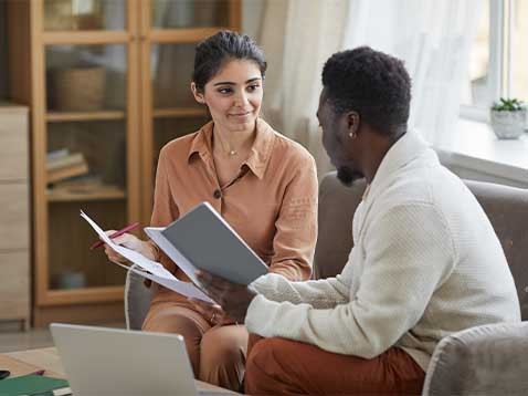 Two professionals sitting down together on a couch
